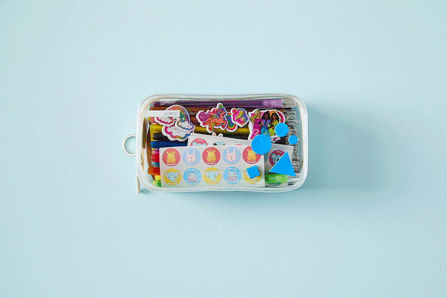 A series of images showing how to organise kids’ travel activity packs, connecting them with hinged rings and a carabiner.