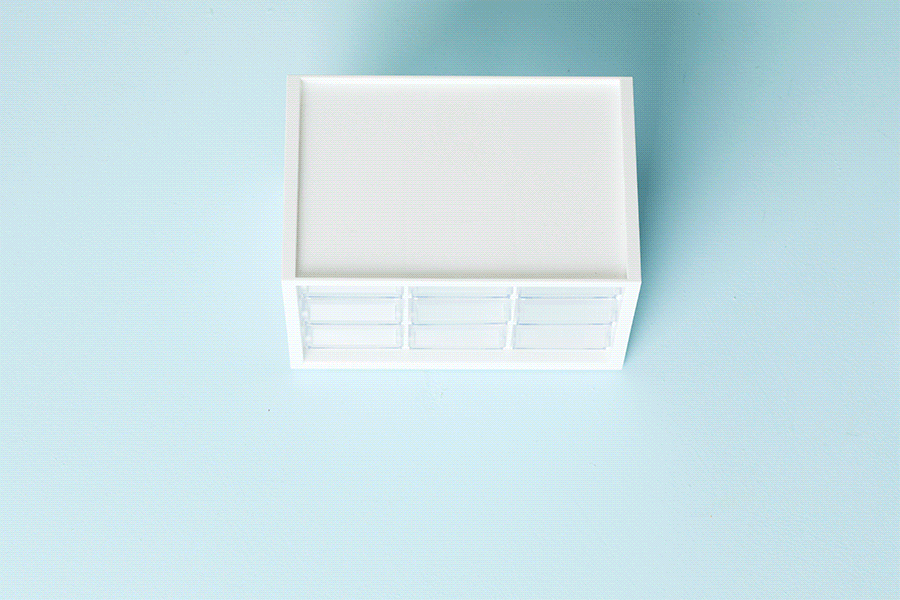A series of images showing how to create an out-the-door bag station. This example shows a set of small plastic drawers being filled with travel items, such as hand sanitiser, pens and cables.