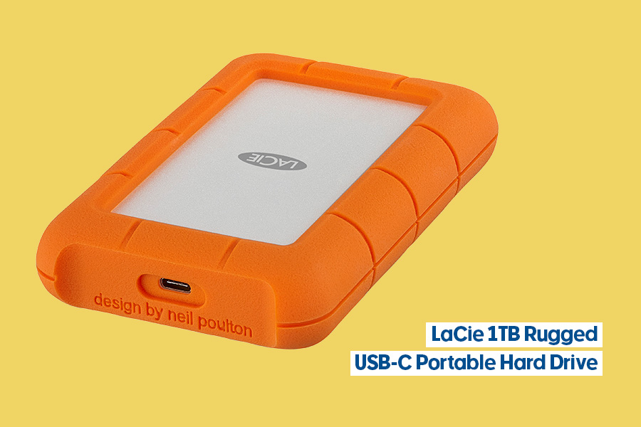 LaCie 1TB Rugged USB-C Portable Hard Drive with orange protective rubber casing, displayed on a yellow background.