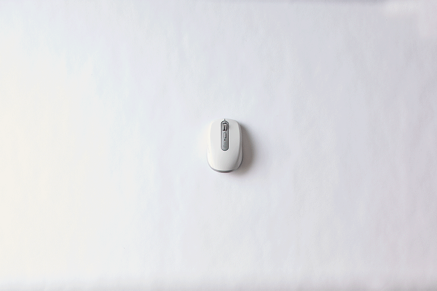 A series of images showing a hand reaching for a white Logitech MX Anywhere 3S Mouse, holding it, turning it over and using the scrolling wheel, before the mouse moves up and out of frame, all shown against a white surface.