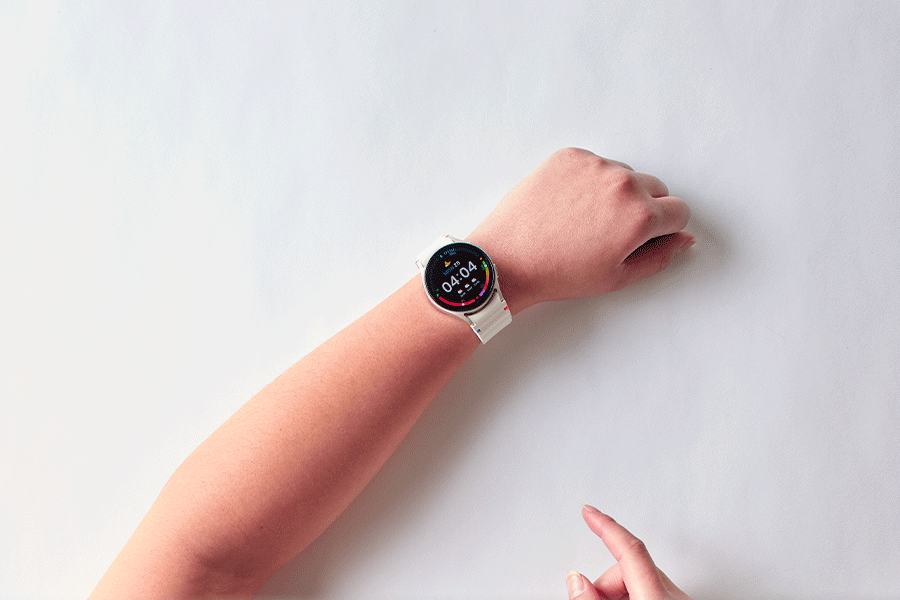 A series of images showing a person interacting with a white Samsung Galaxy Watch7 displaying various screens, including time, fitness tracking and energy score, all shown against a white surface.