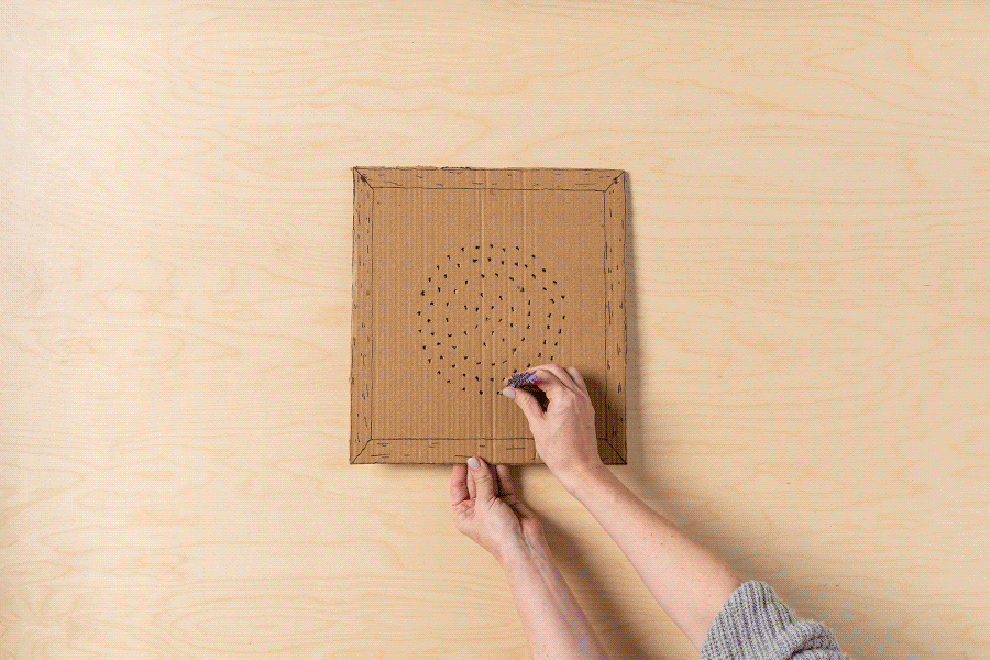 A series of images showing how to thread flowers through holes in a piece of cardboard, eventually filling all holes to create a bouquet.