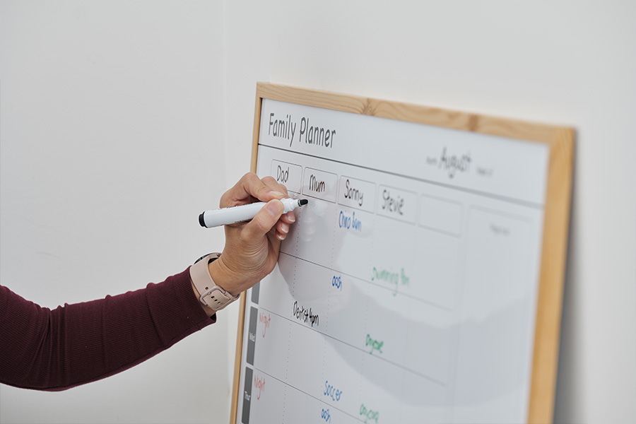 Pip Renfrew writes on a family planner whiteboard calendar.