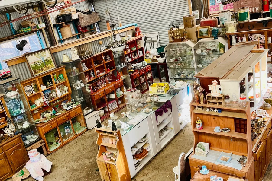 A high-up view of the inside of the Rustyque store, showing a variety of display cabinets filled with antique items, including kitchenware, art and ornaments.