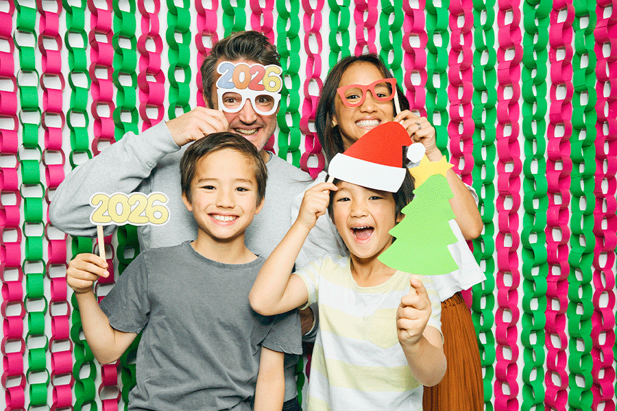 A series of images showing a family of four posing for Christmas photos with cardboard props, including a star, a Santa hat and a Christmas tree.