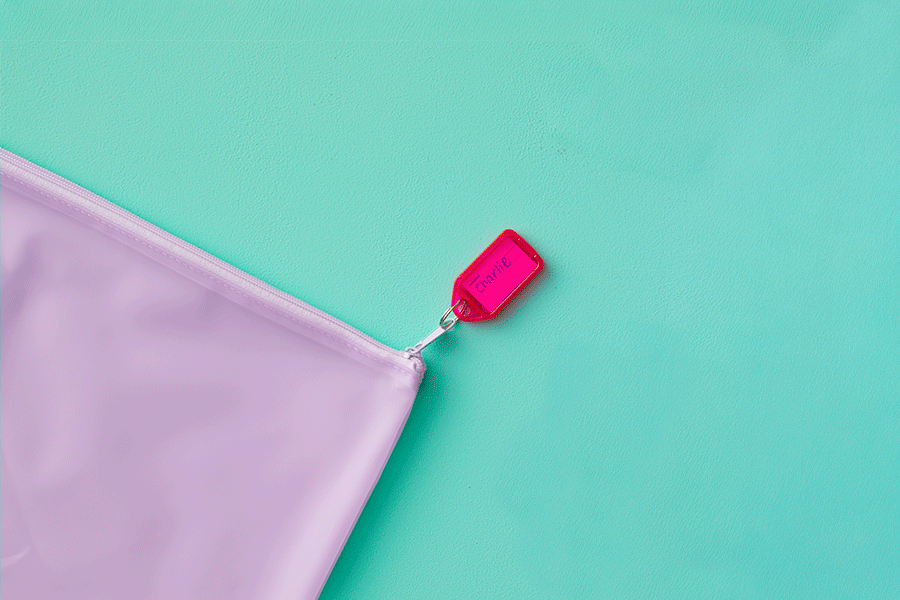 A GIF series showing a key ring tag that says ‘Charlie’, being used as kids’ name label for a purple pencil case, and surrounded by other key rings of different colours and sizes.