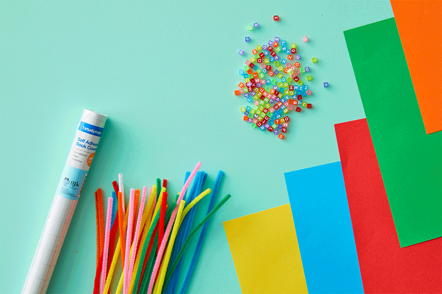 A GIF series of alphabet beads, pipe cleaners, coloured cardboard, clear contact paper and handmade tags with the names ‘Joey’ and ‘Alex’ written on them.