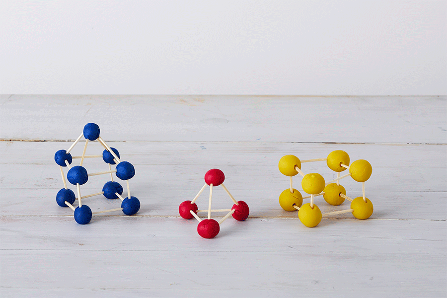 A series of images showing three spinning geometric structures made from matchsticks and balls of blue, red and yellow playdough.