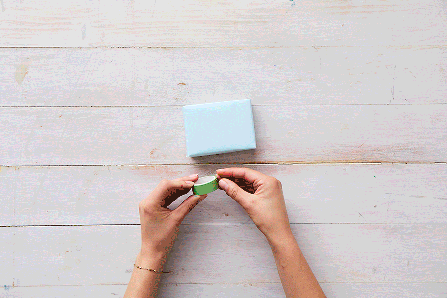 A series of images demonstrating Step 3 of making recycled box builders, showing hands decorating paper-wrapped boxes with colourful washi tape and stickers.
