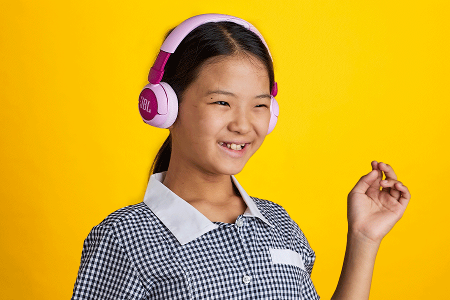 A series of images showing kids wearing headphones, such as wireless purple on-ear headphones and wired black on-ear headphones.