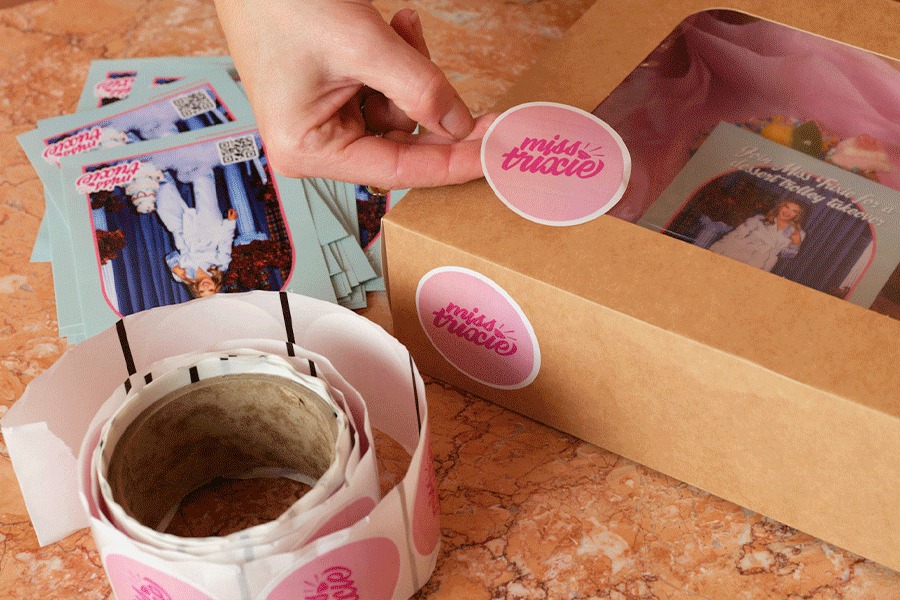 A series of images showing an assortment of Miss Trixie’s custom brand stationery. Products include flyers and stickers being applied to packages.
