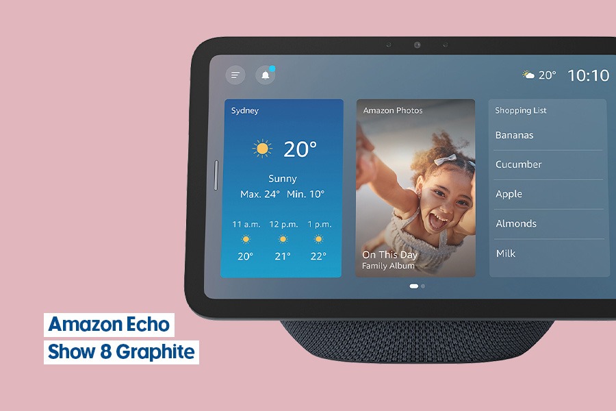 Amazon Echo Show 8 Graphite smart speaker and screen displaying weather, a family photo and shopping list, shown against a pink background