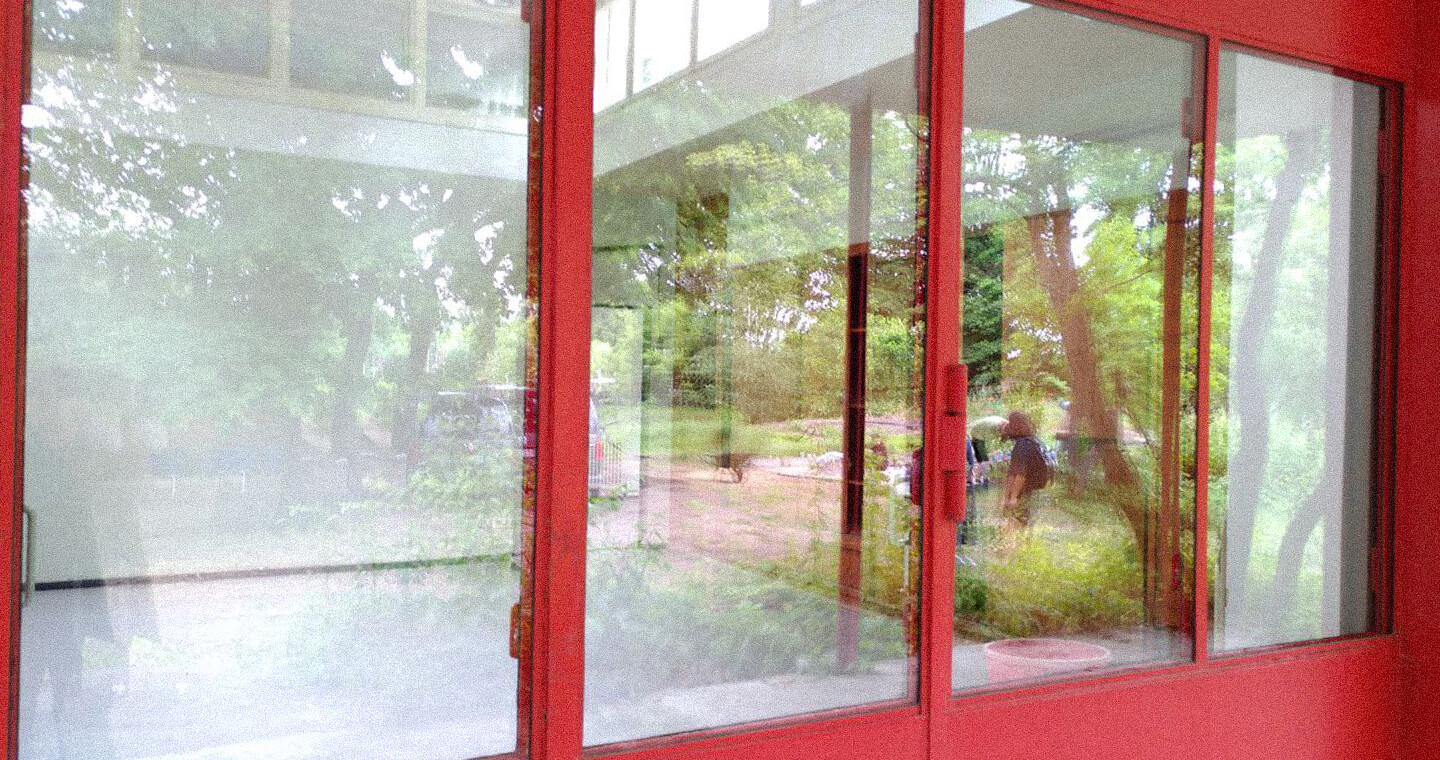 A Reflection of people and trees on a Glassdoor.