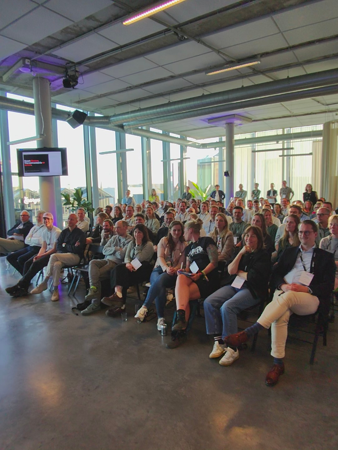 A tech crowd, attentively watching the screen.