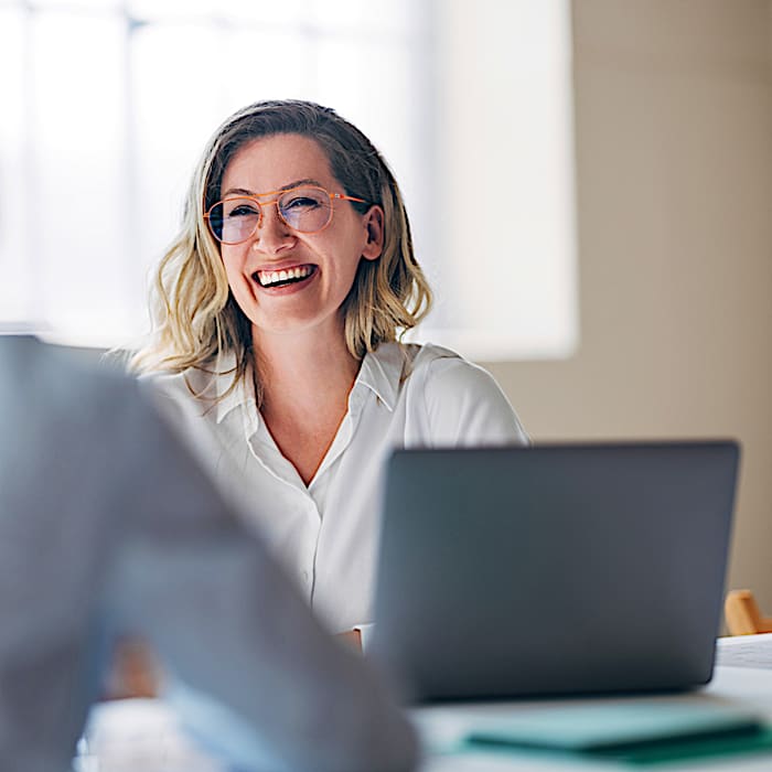 Woman working at a laptop, illustrating that resivo business access control is cloud-native software managed from any browser rather than hardware.