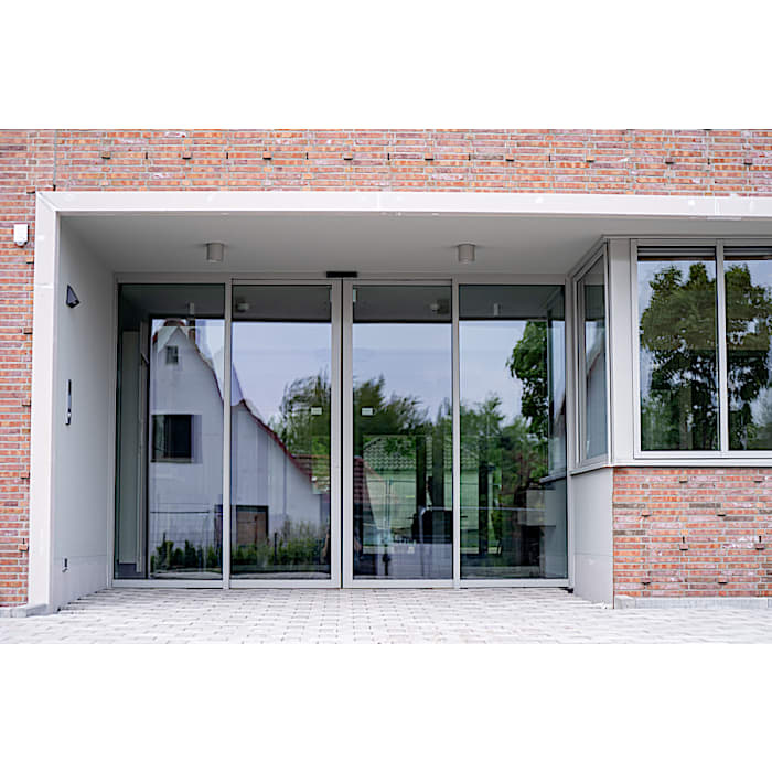 Installed ST PRO Green glazed automatic sliding door in a brick facade, showing the burglary-resistant RC3 entrance in situ.