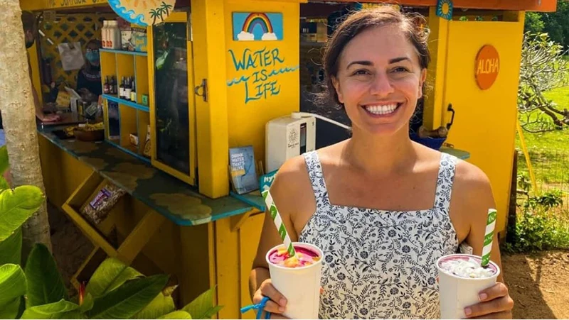 A lady holding two drinks