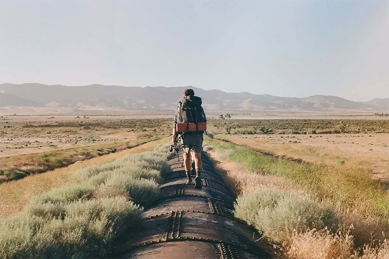 A man backpacking on a trail.