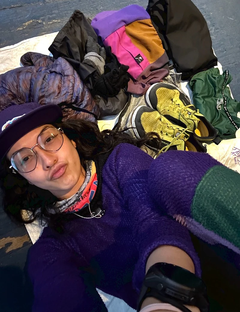 A lady laying on hiking gear.