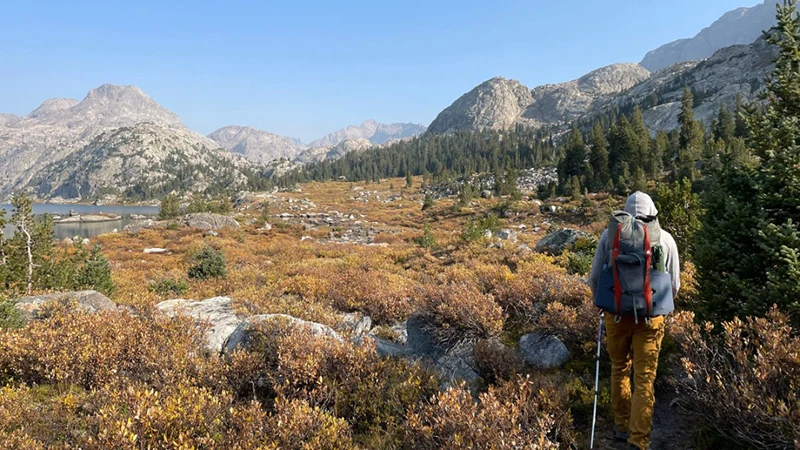 A person hiking in front of a mountain.