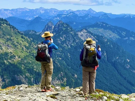 Two hikers overlooking a mountain.