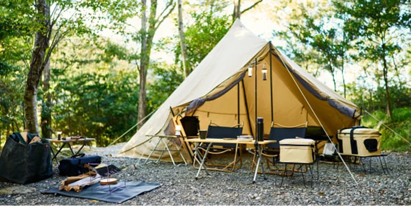 A tent at a campsite in the woods.