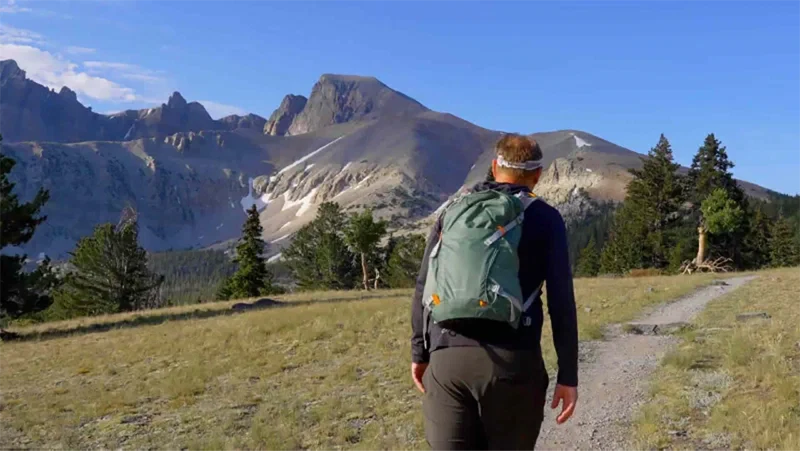 A hiker with a backpack on a mountain trail.