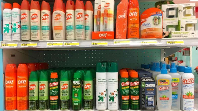 Bottles of bug spray on shelves at a store.