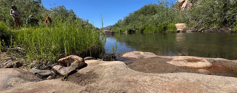 People standing near a stream.