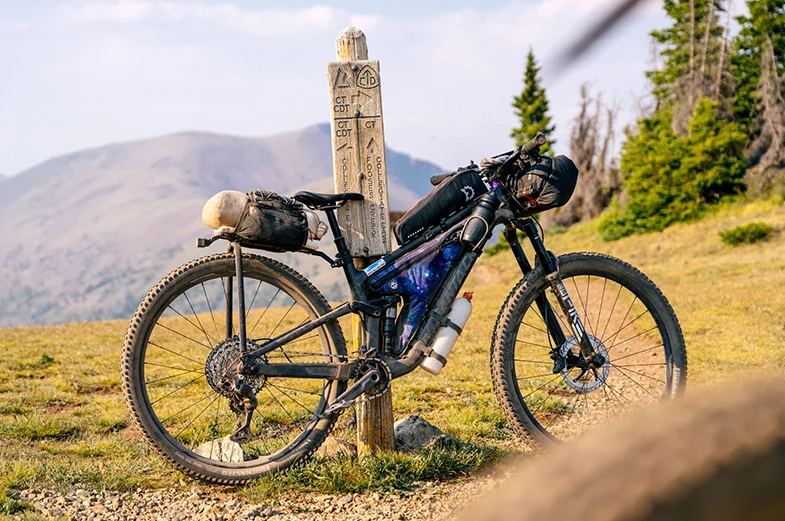 A bike near a trail sign.