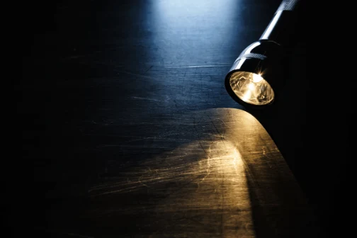 A flashlight on a table.