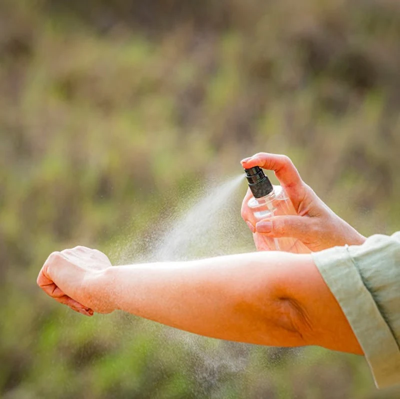 A mosquito repellent being sprayed on an arm.