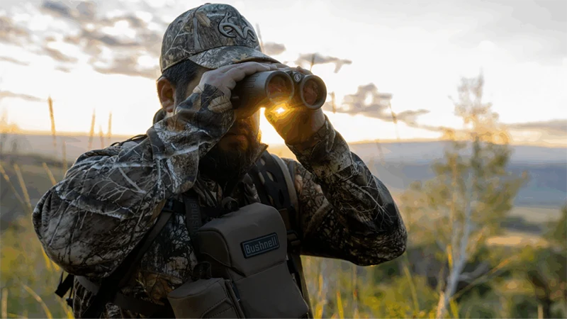 A hunter looking through binoculars.