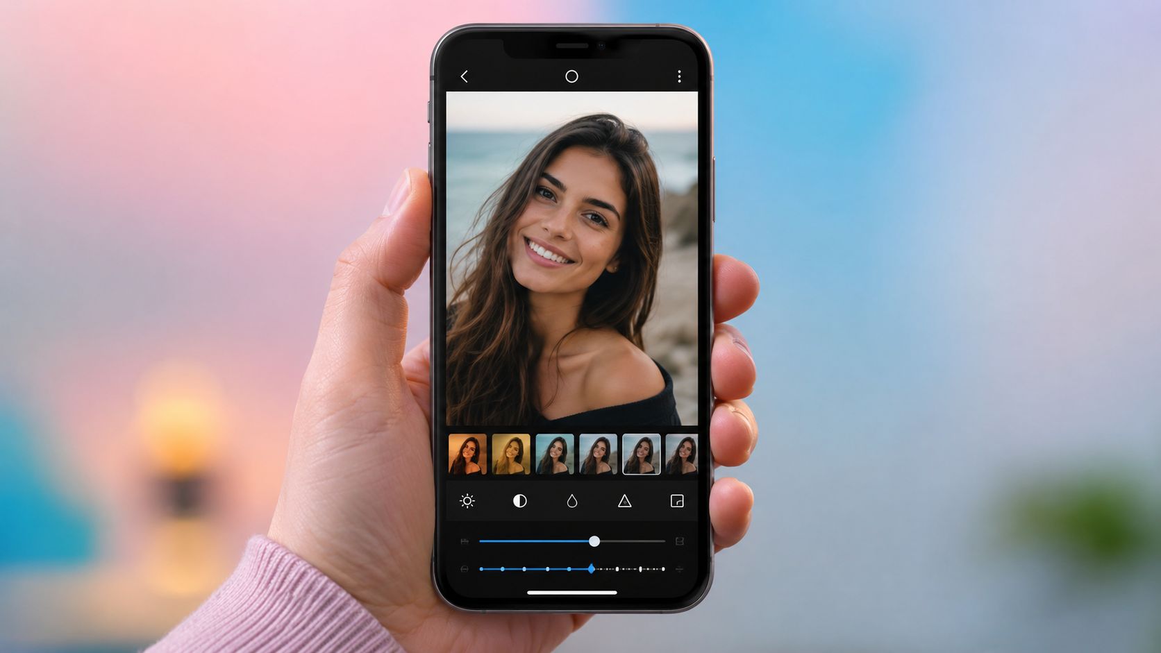 A hand holding a smartphone showing a portrait being edited in a photo editor application.