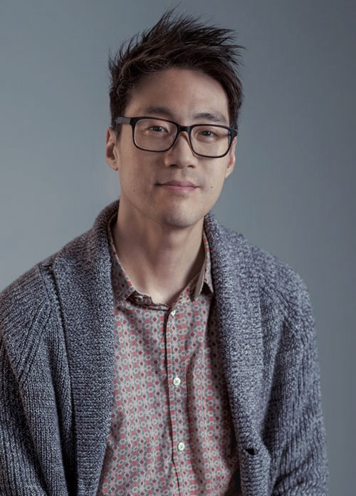 A man with glasses is posing for a picture