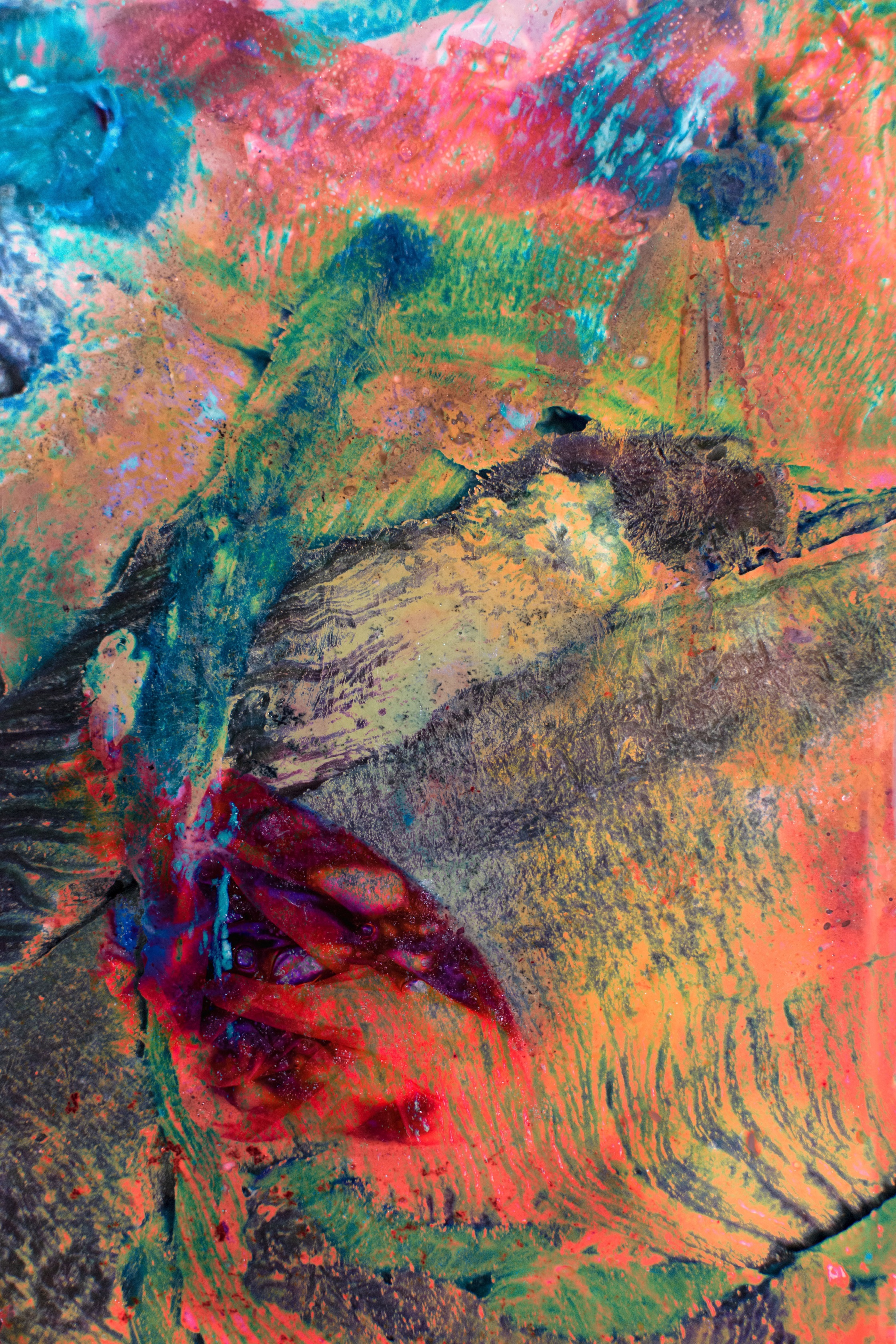 Close-up of a textured abstract painting with vibrant colors including red, blue, green, and yellow blending and overlapping.