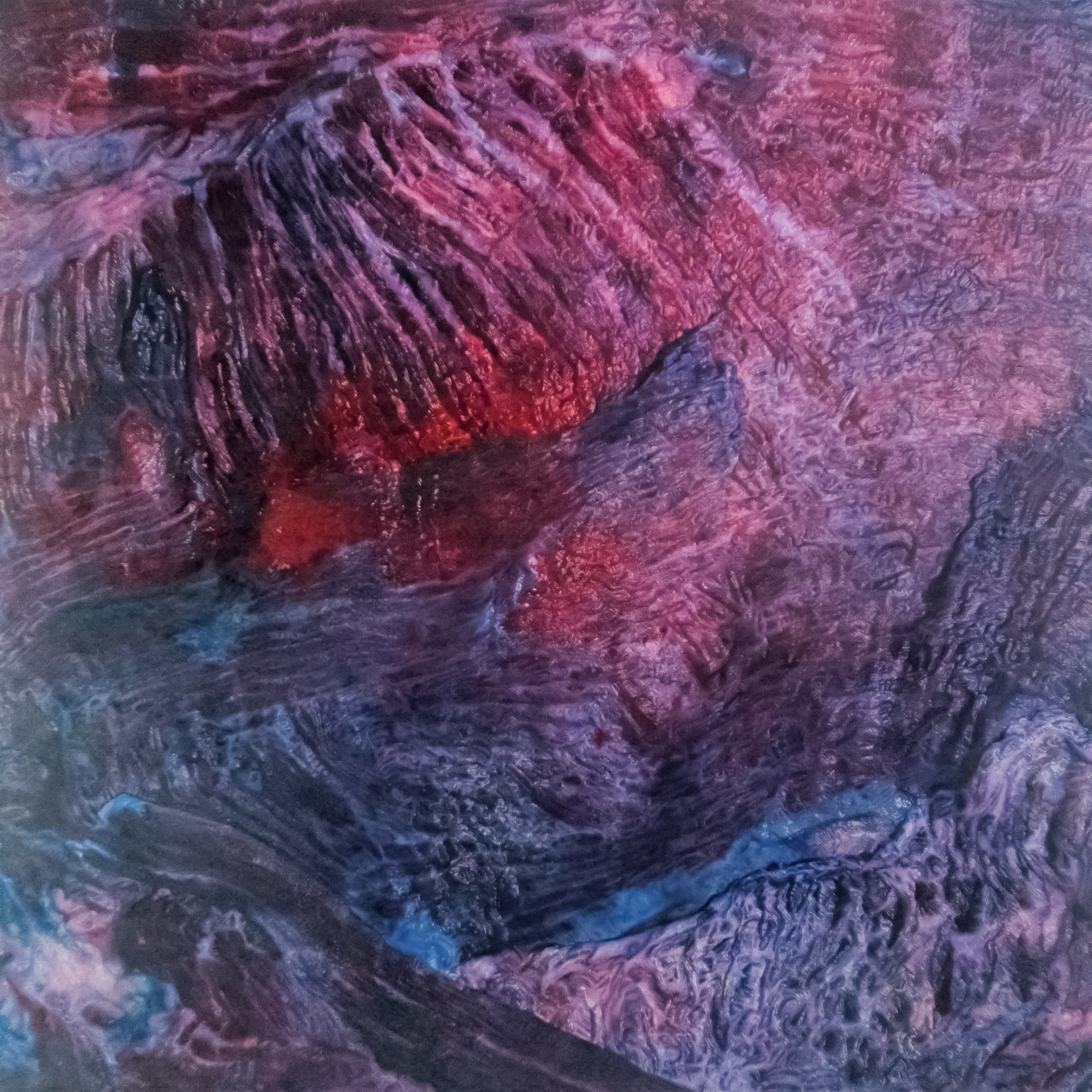 Close-up of textured surface with swirling patterns in deep red, purple, and blue hues.