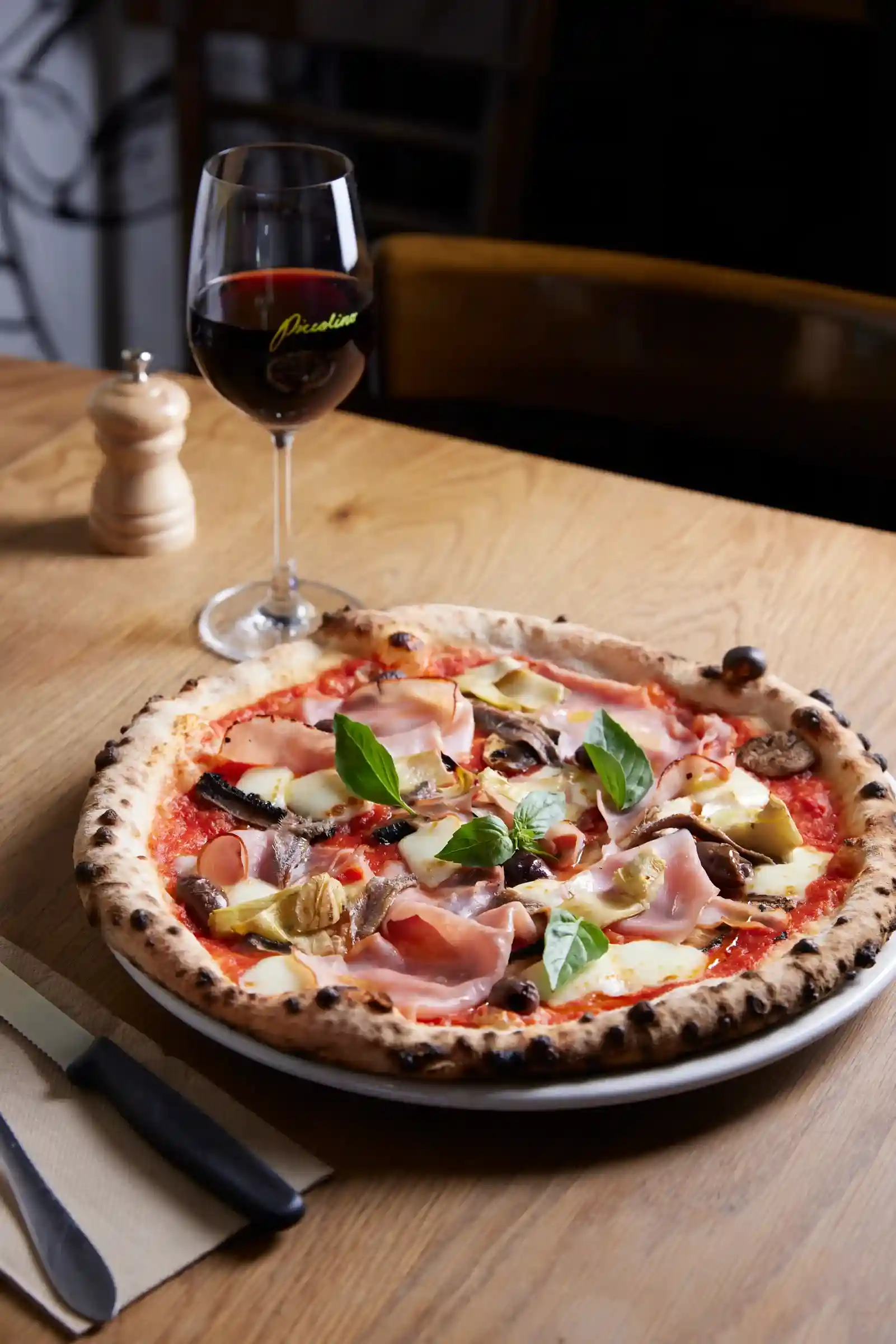 Woodfired pizza with a glass of wine
