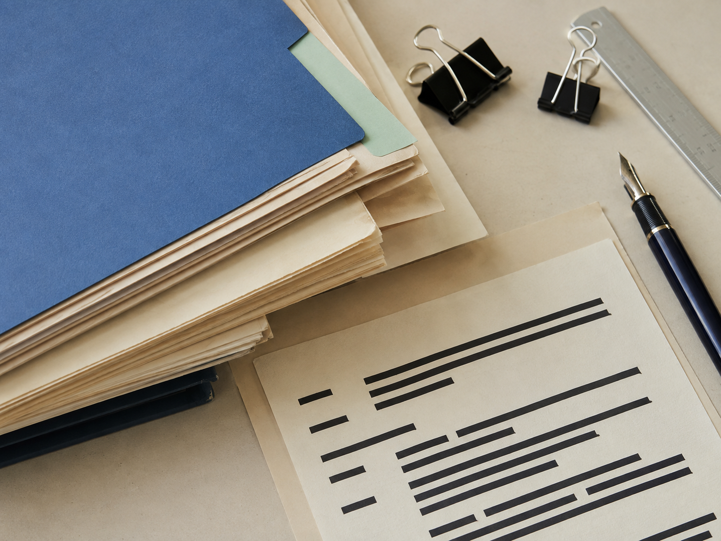 An editorial still life of archival folders, clipped documents, a fountain pen, and redacted paper