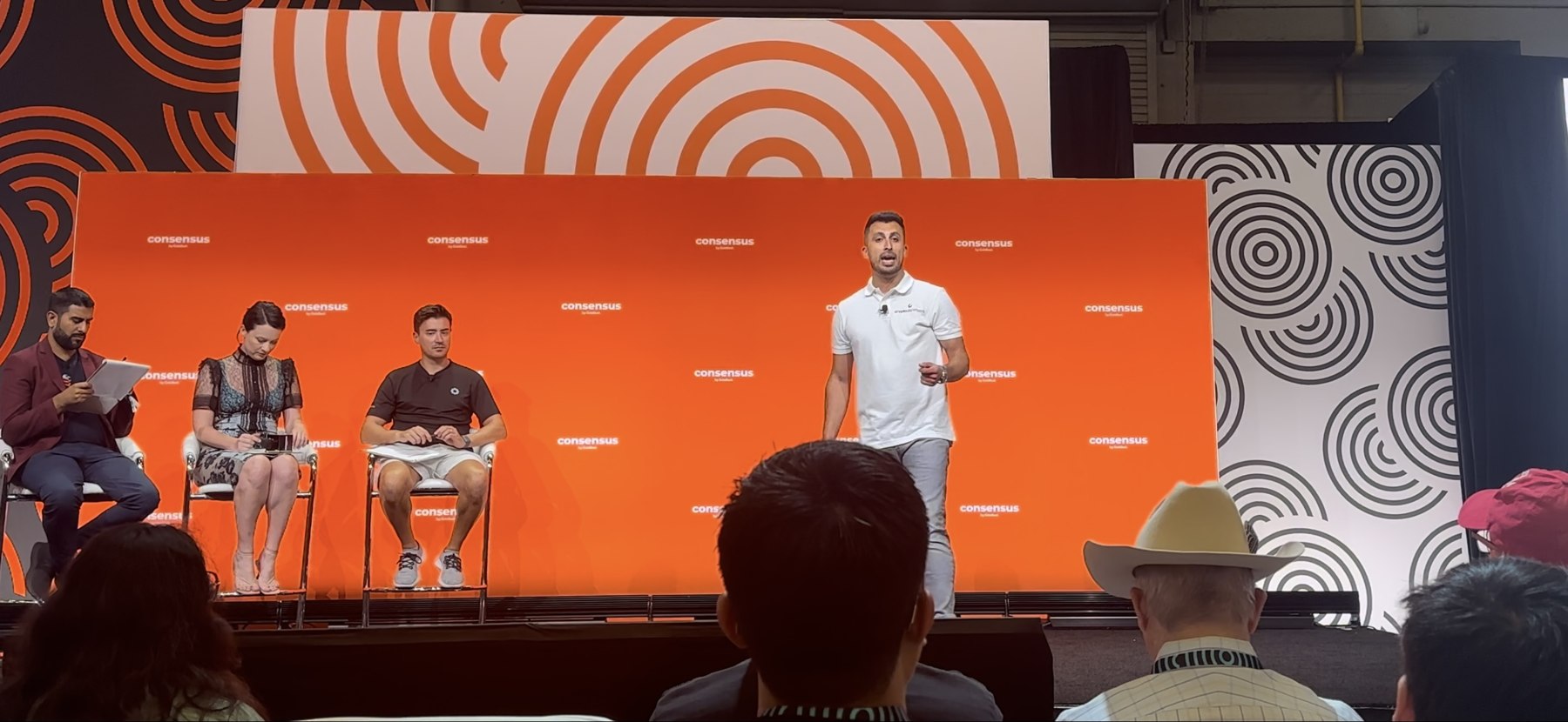 Crypto Dispensers founder Firas Isa delivering the Bitcoin pitch at Consensus 2024 PitchFest, with panelists and audience members.
