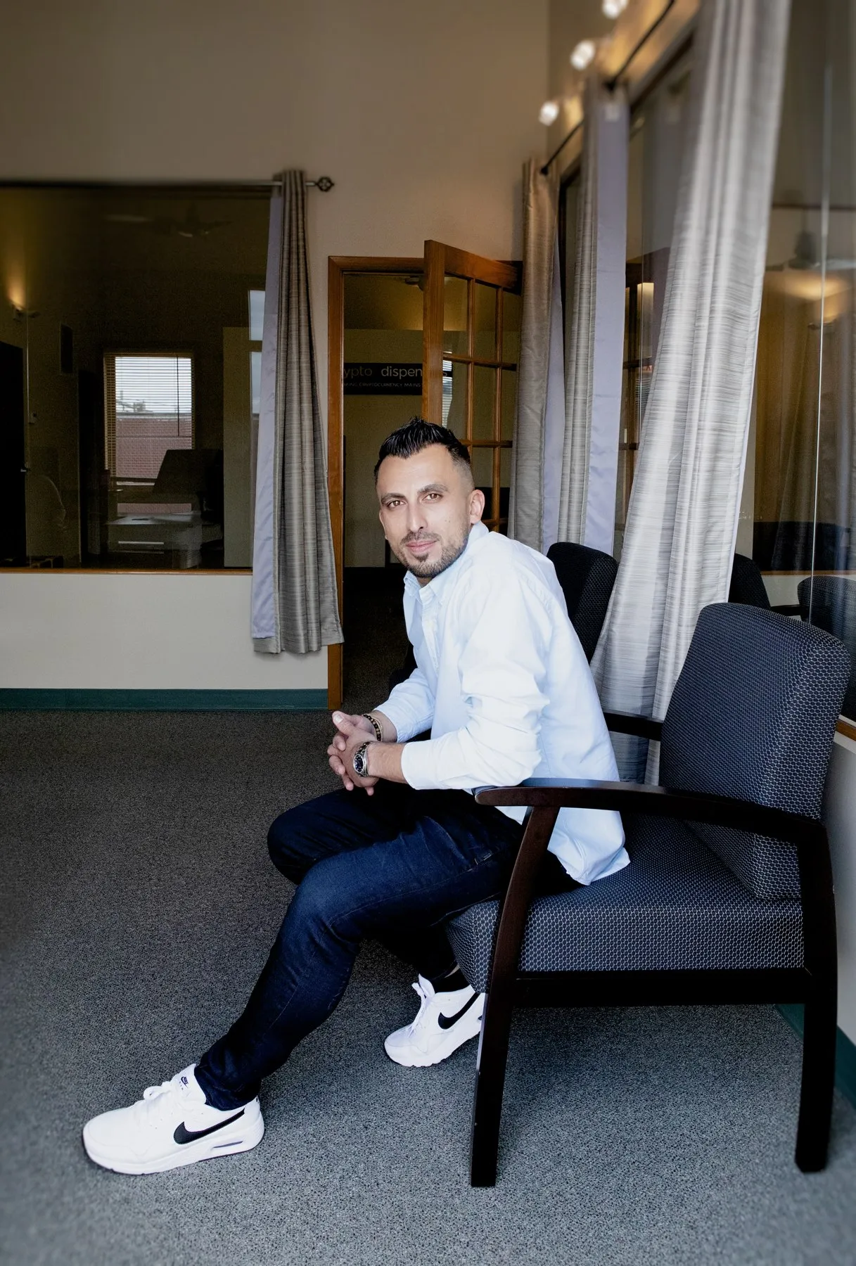 Firas Isa seated in the Crypto Dispensers office during the April 2021 photo shoot.