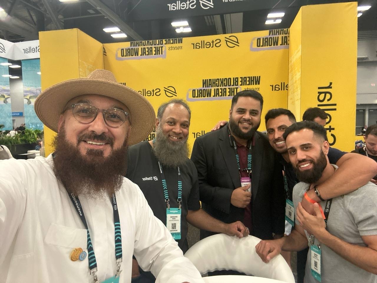 Firas Isa with fellow attendees beside an exhibition booth at Consensus.
