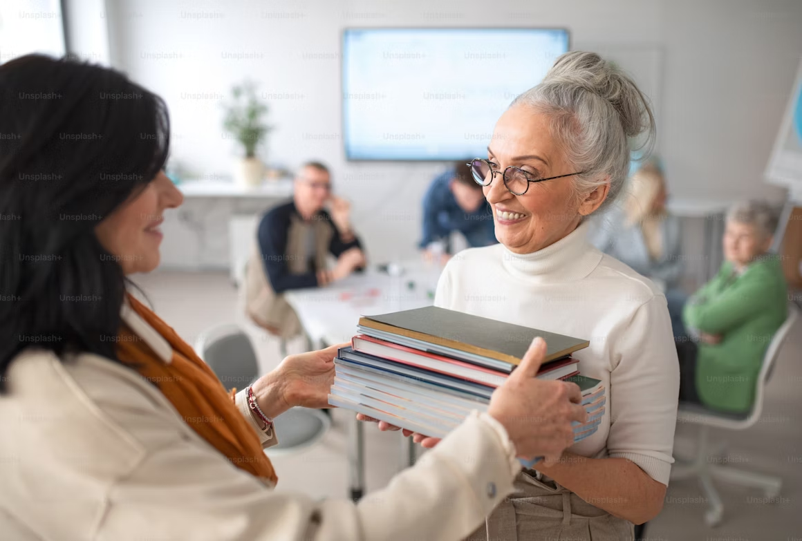 Experienced teacher welcoming and mentoring a new colleague during teacher onboarding at school.