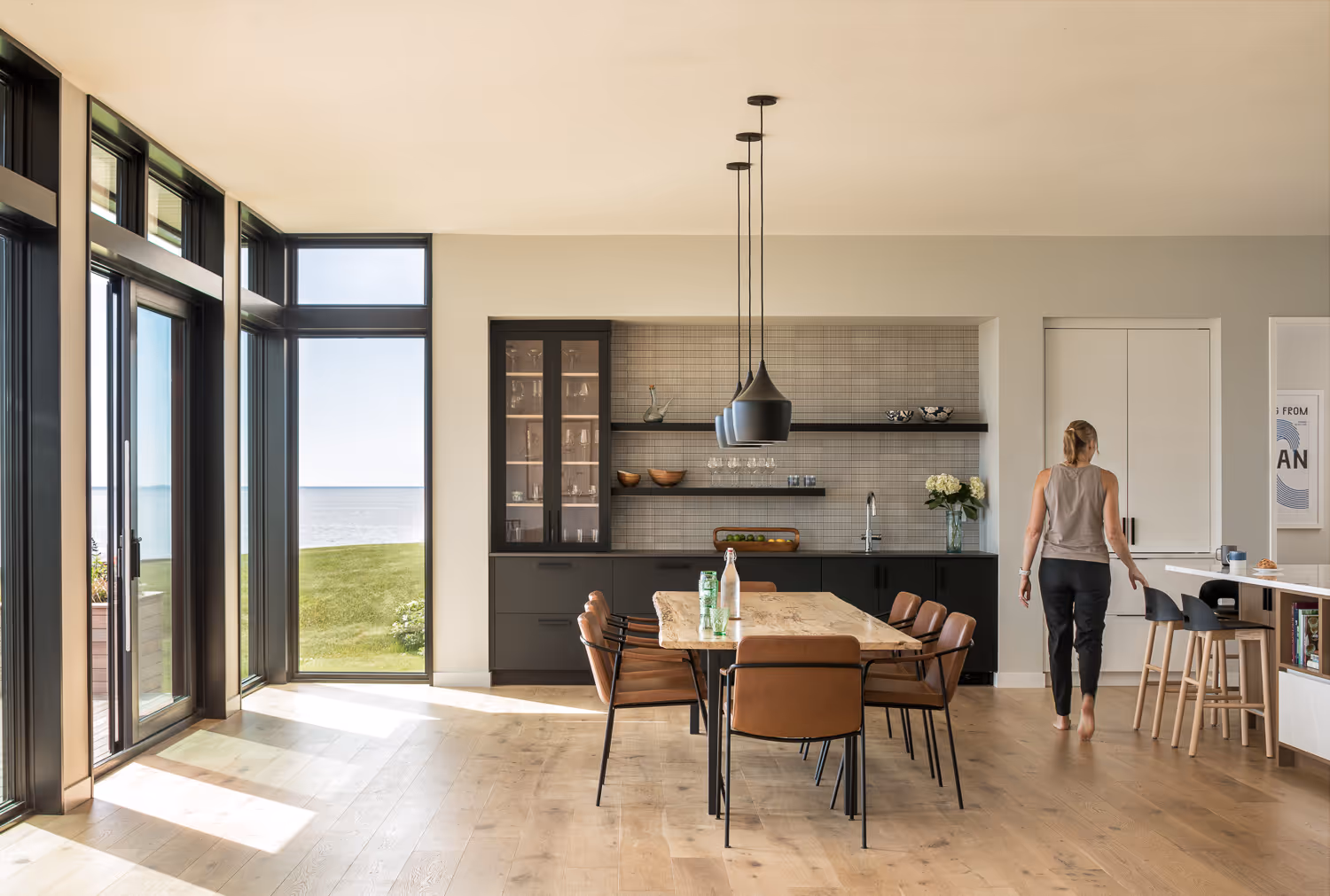 Modern kitchen with ocean view, wooden table, and large windows