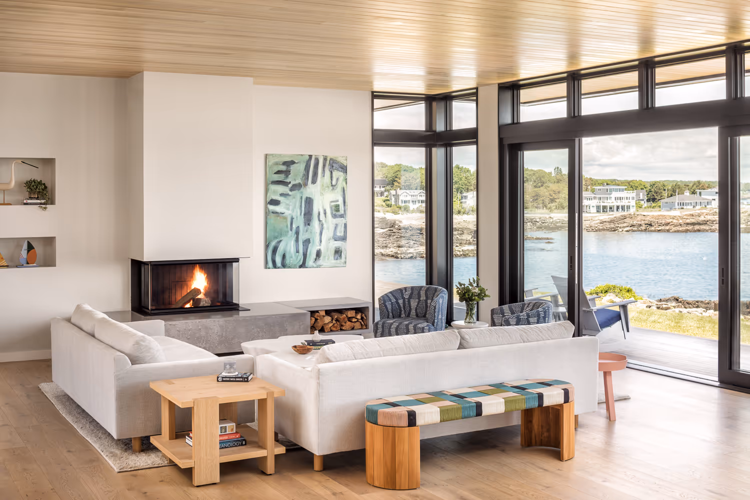 Modern living room with fireplace and ocean view through large windows