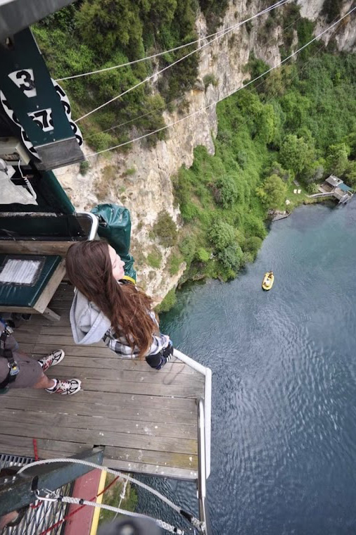 Person standing on platform high above body of water