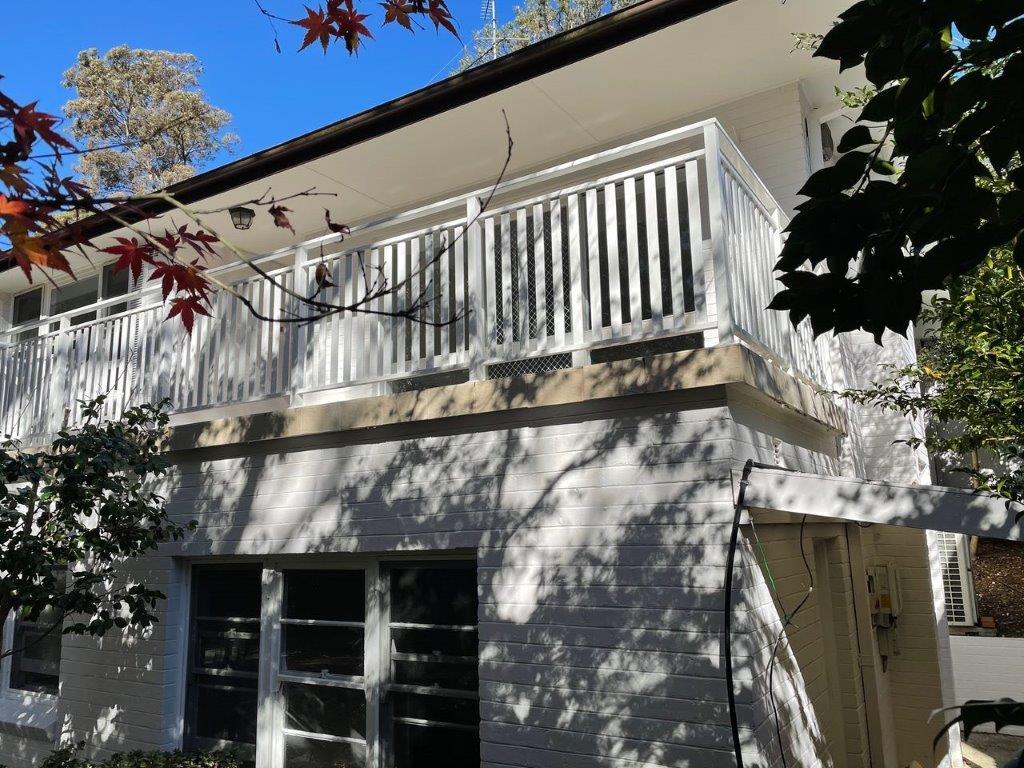 White aluminium balcony balustrade on a rendered house
