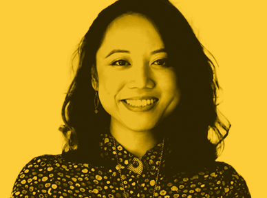 An image of a confident and professional woman. They have a patterned shirt. The image is tinted yellow.