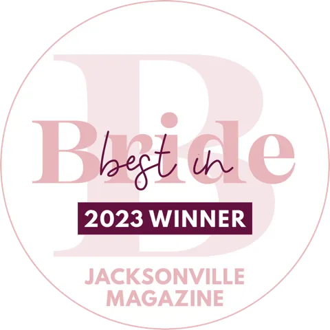 Circular badge with text Best in Bride 2023 Winner Jacksonville Magazine in pink and purple tones.