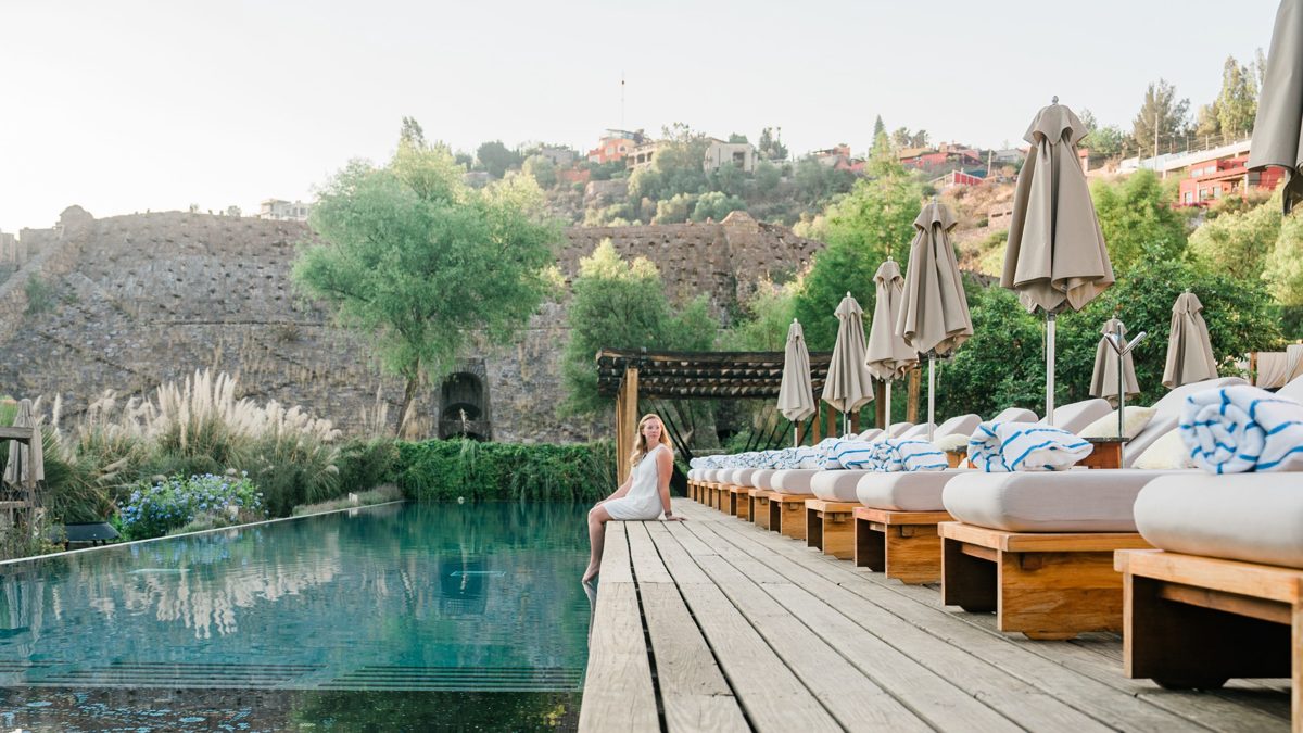 Girl sitting with her feet in the pool at Live Aqua San Miguel de Allende, Mexico hotel